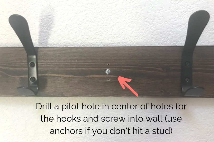 Instructions for hiding screws when attaching coat rack to the wall - drill a pilot hole under hooks